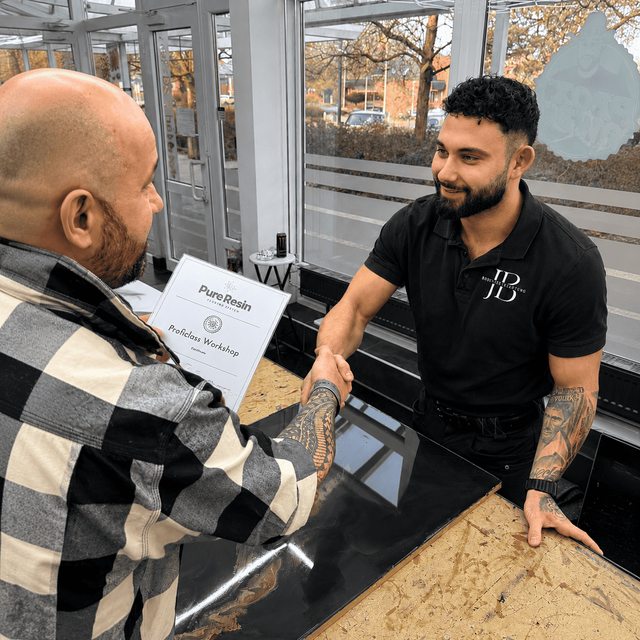 Teilnehmer erhält nach erfolgreichem PureResin Workshop sein Zertifikat bei der persönlichen Übergabe.