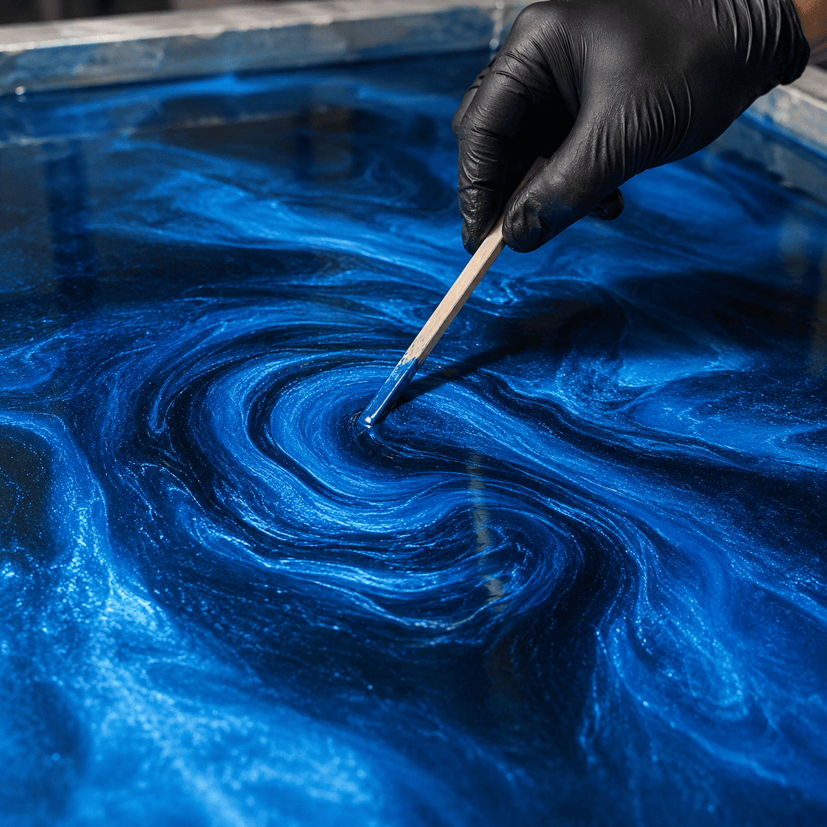 Blaues Metallic-Epoxidharz wird mit Holzstab zur Marmorstruktur gestaltet
