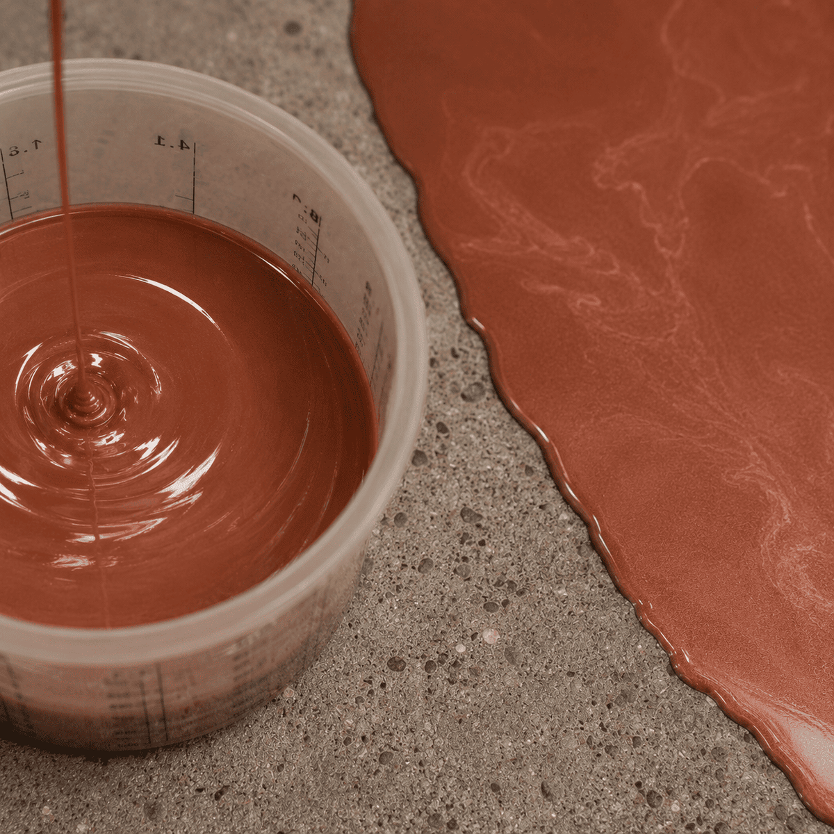Hellbraunes Metallic-Epoxidharz im Mischbecher neben einer frisch beschichteten Musterfläche in warmer Kaffeebraun-Optik