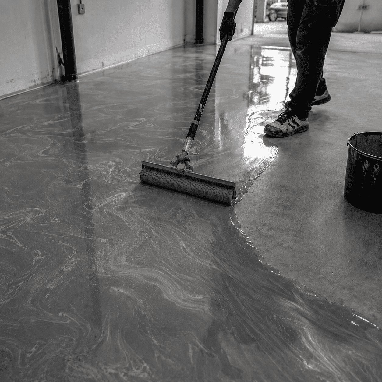 Verarbeitung eines Light Grey Metallic-Epoxidharzbodens mit Entlüftungswalze für gleichmäßige silbergraue Marmorierung und glänzende Oberfläche.