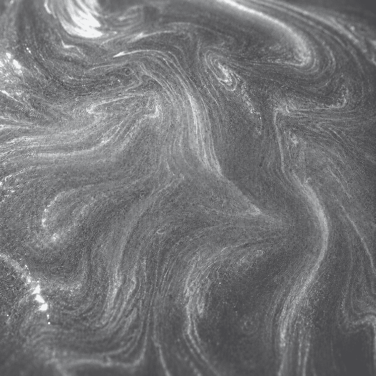 Nahaufnahme einer silbergrauen Metallic-Oberfläche mit feiner Marmorierung und schimmernden Lichtreflexen für Epoxidharzböden.