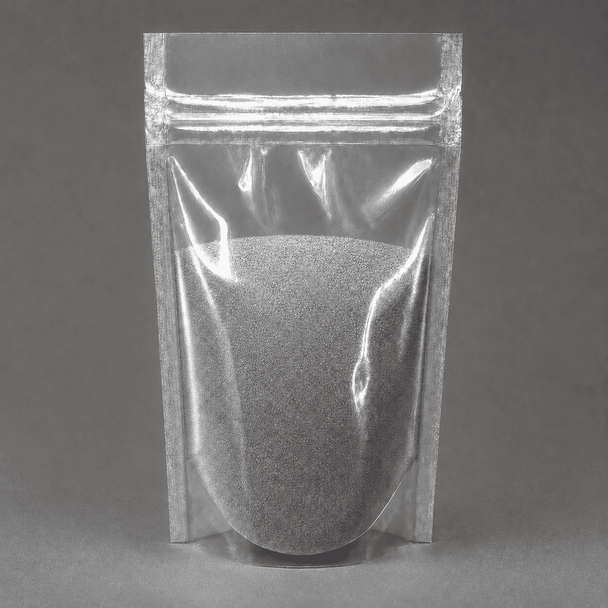 Metallic Pigment Light Grey als silbergraues Pulver in transparenter Standbodenverpackung auf neutralgrauem Hintergrund.
