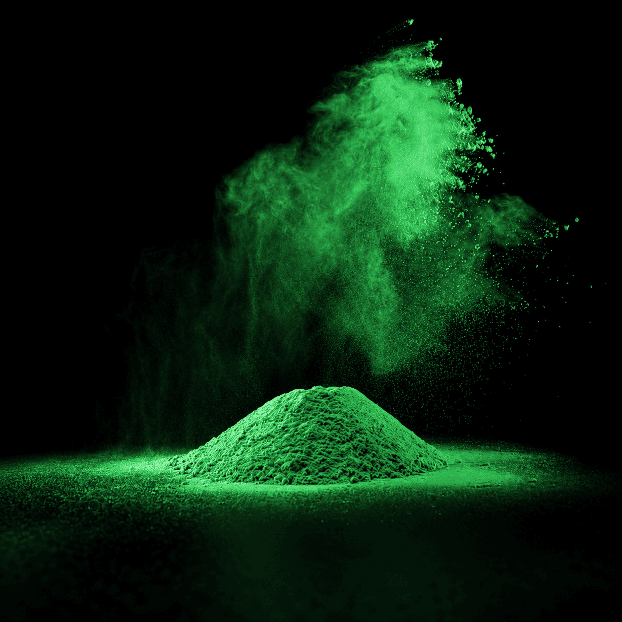 Hellgrünes Pulver auf schwarzem Hintergrund