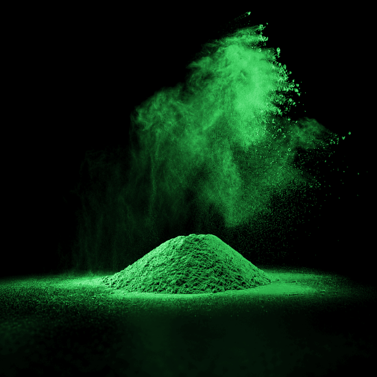 Hellgrünes Pulver auf schwarzem Hintergrund