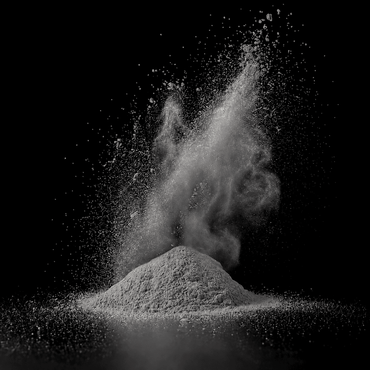 Metallic Pigment Light Grey als feines silbergraues Pulver mit aufgewirbelten Partikeln vor schwarzem Hintergrund.