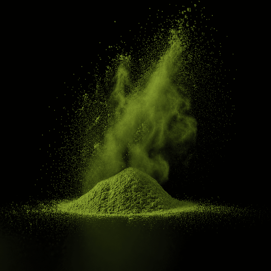 Smaragdgrünes Metallic-Pigment als feines Pulver mit dynamischer Staubwolke vor schwarzem Hintergrund.