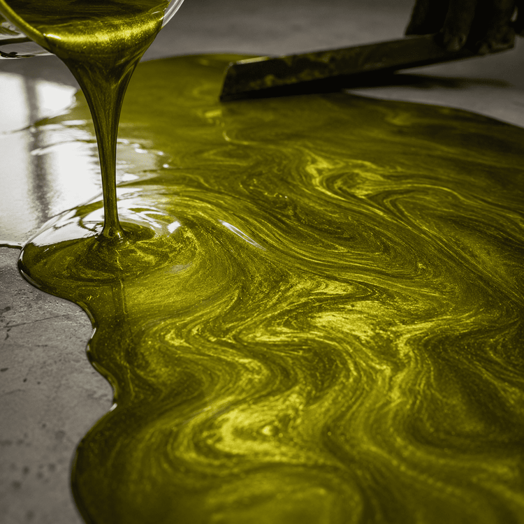 Olivegrün gefärbtes Harz wird aus einem Eimer auf den Boden gegossen