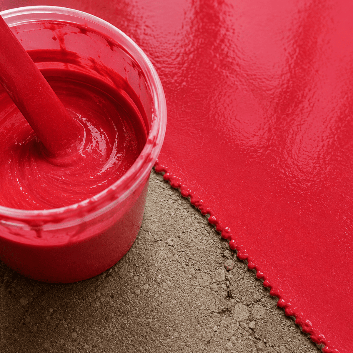 Leuchtend rotes Metallic-Epoxidharz im Mischbecher neben einer frisch beschichteten Betonfläche mit intensivem Glanz, gleichmäßiger Oberfläche und moderner Farbwirkung.