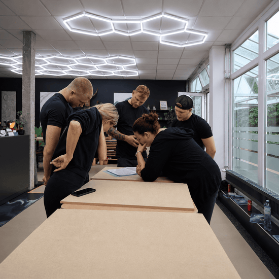 Eine Gruppe von Schulungsteilnehmern besprechen den Ablauf am Tisch im Showroom in Trappenkamp