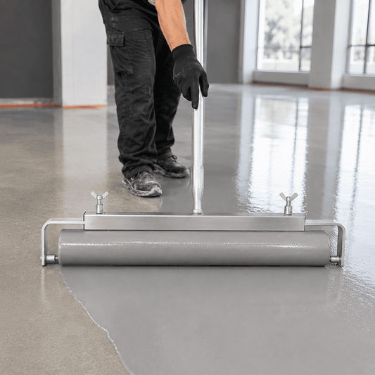 Ein Mann verwendet den aluminium Walzenbügel um einen Boden in grau zu streichen