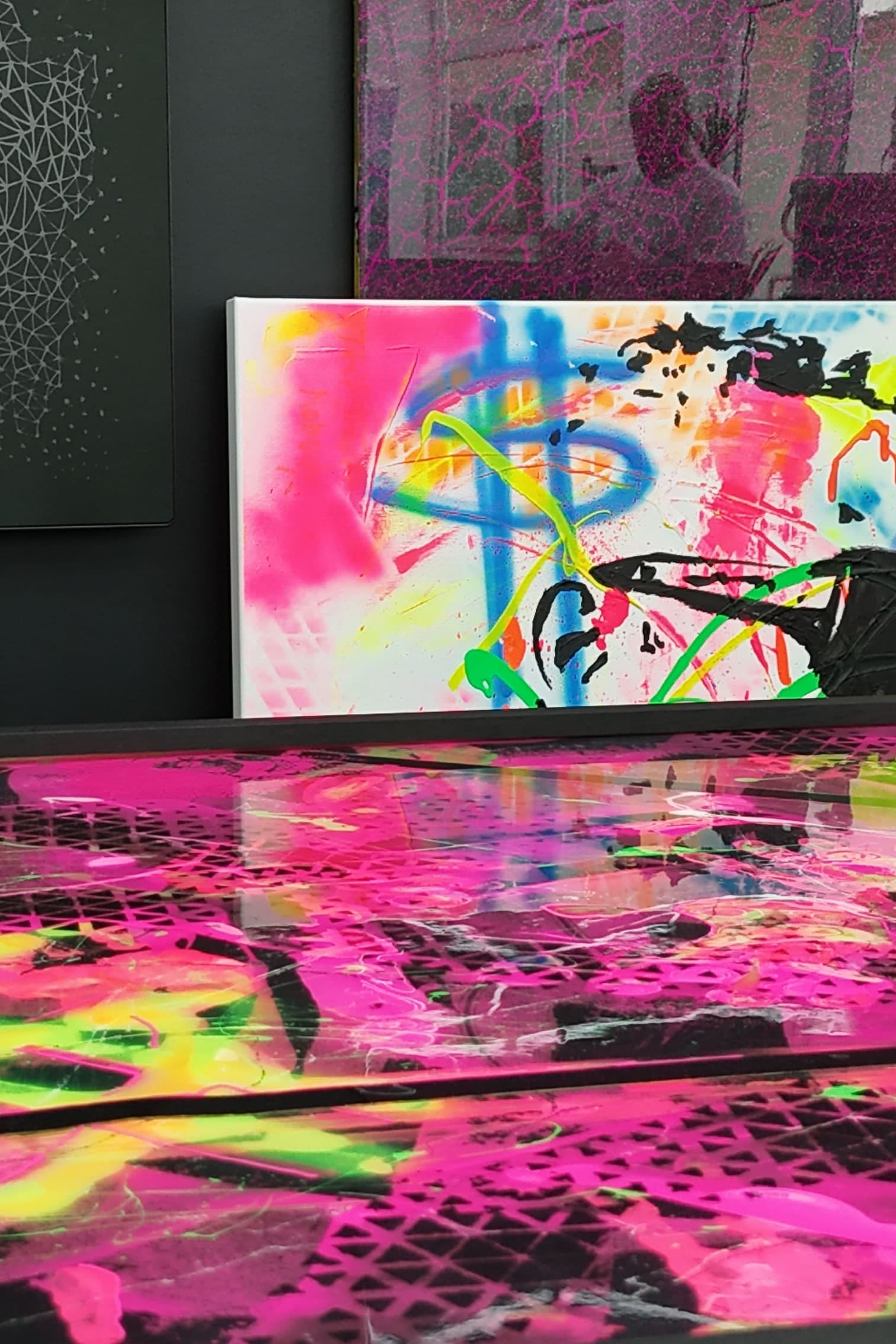 Bunte Epoxidharz-Kunst mit Neonfarben auf einer fugenlosen Hochglanzoberfläche im Pure Resin Flooring Showroom.