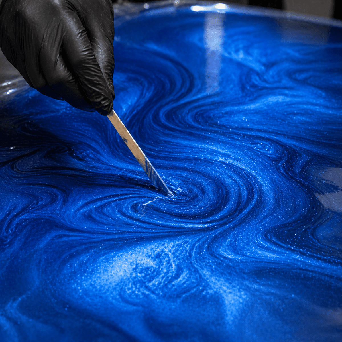 Sky Blue UV Metallic-Epoxidharz wird mit einem Holzspatel zu einer luxuriösen Marmorstruktur mit brillantem Perleffekt, strahlendem Himmelblau-Schimmer und faszinierender Tiefenwirkung gestaltet.