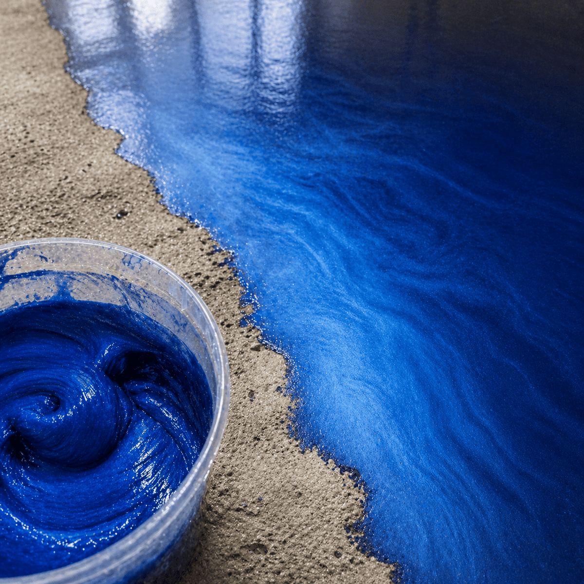 Sky Blue UV Metallic-Epoxidharz im Mischbecher neben einer fertigen Musterplatte mit strahlender Himmelblau-Optik, luxuriöser Marmorstruktur, brillantem Perleffekt und hochglänzender Tiefenwirkung.