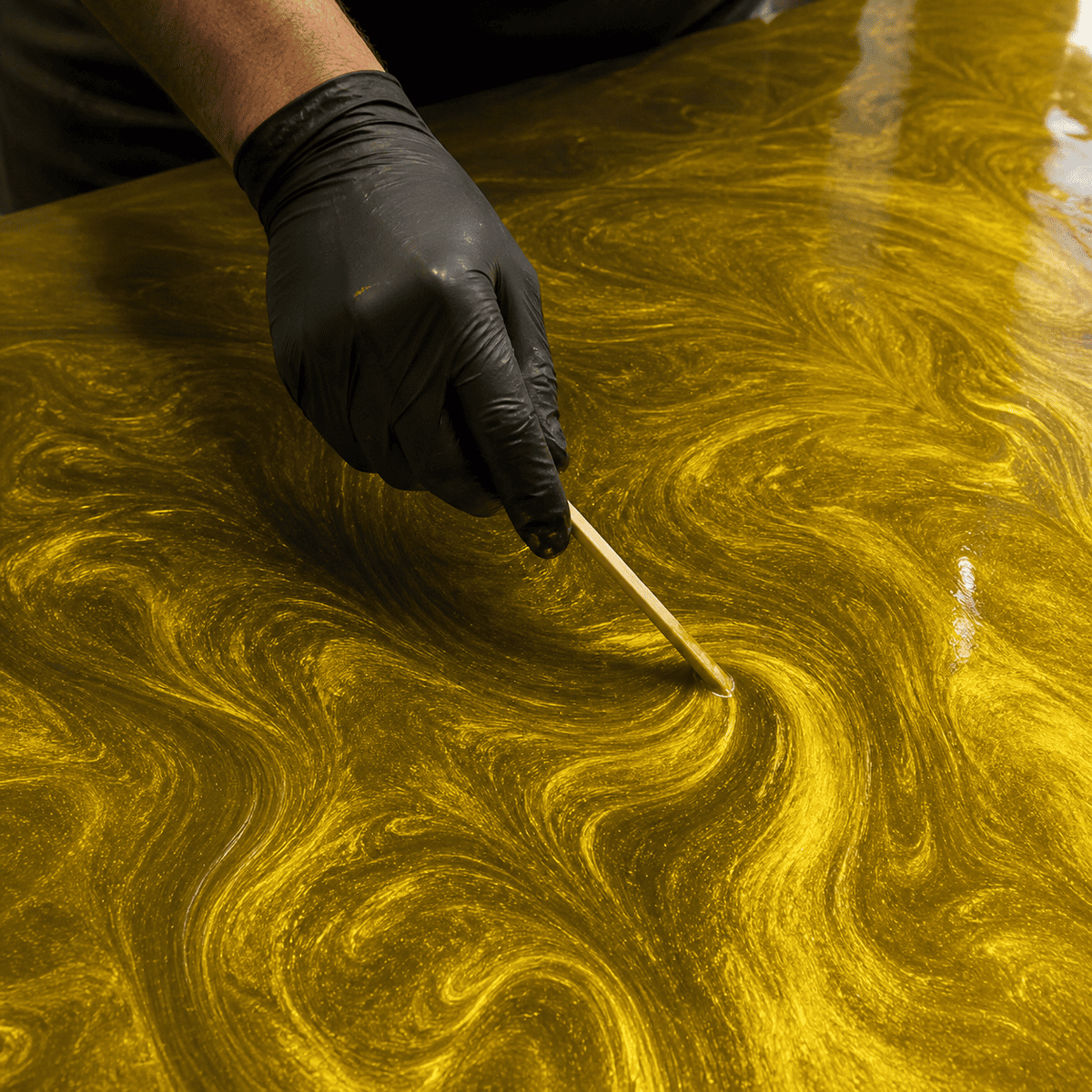 Sunset Gold UV Metallic-Epoxidharz wird mit einem Holzspatel zu einer luxuriösen Marmorstruktur mit intensivem Perleffekt, brillantem Goldschimmer und faszinierender Tiefenwirkung gestaltet.